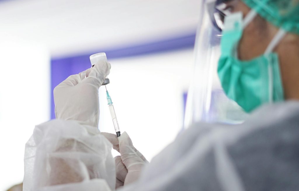 a medical professional using a syringe